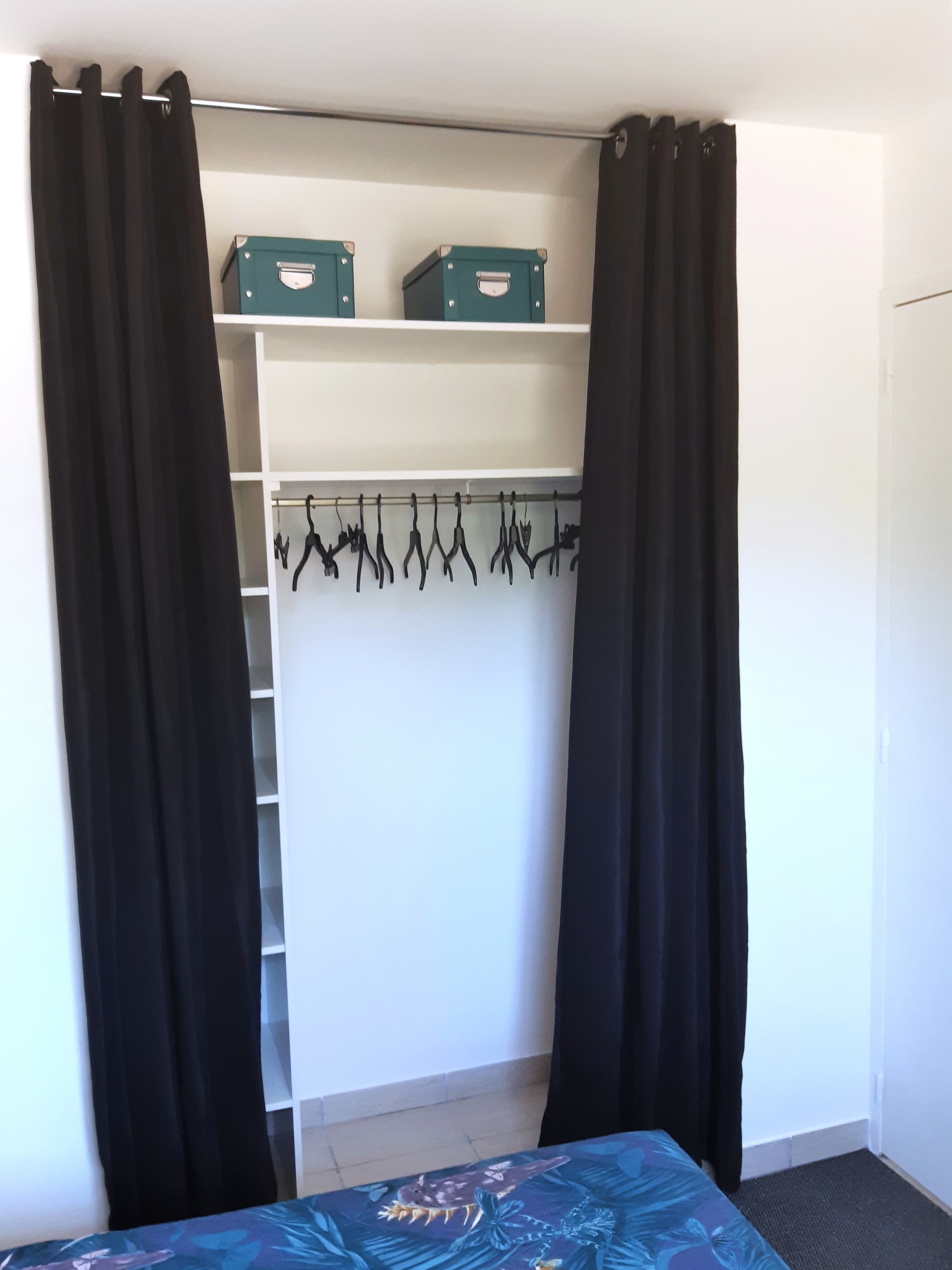 Dressing du gîte naturiste DACANIRO avec petit coffre, cintres, étagères et rideaux