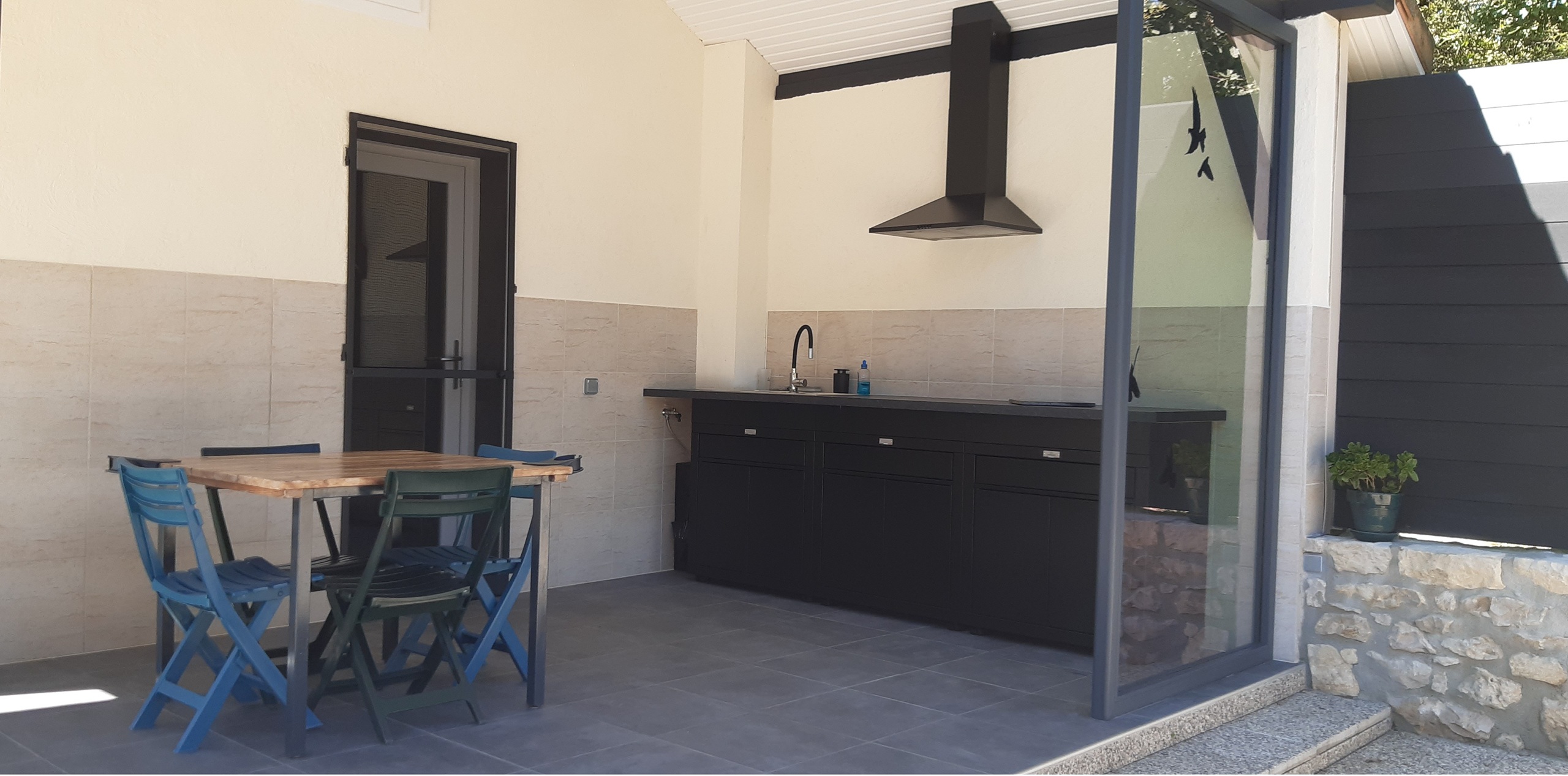 Terrasse couverte avec cuisine d’été équipée d’un barbecue électrique, d’une plancha électrique et d’un four du Gîte naturiste DACANIRO
