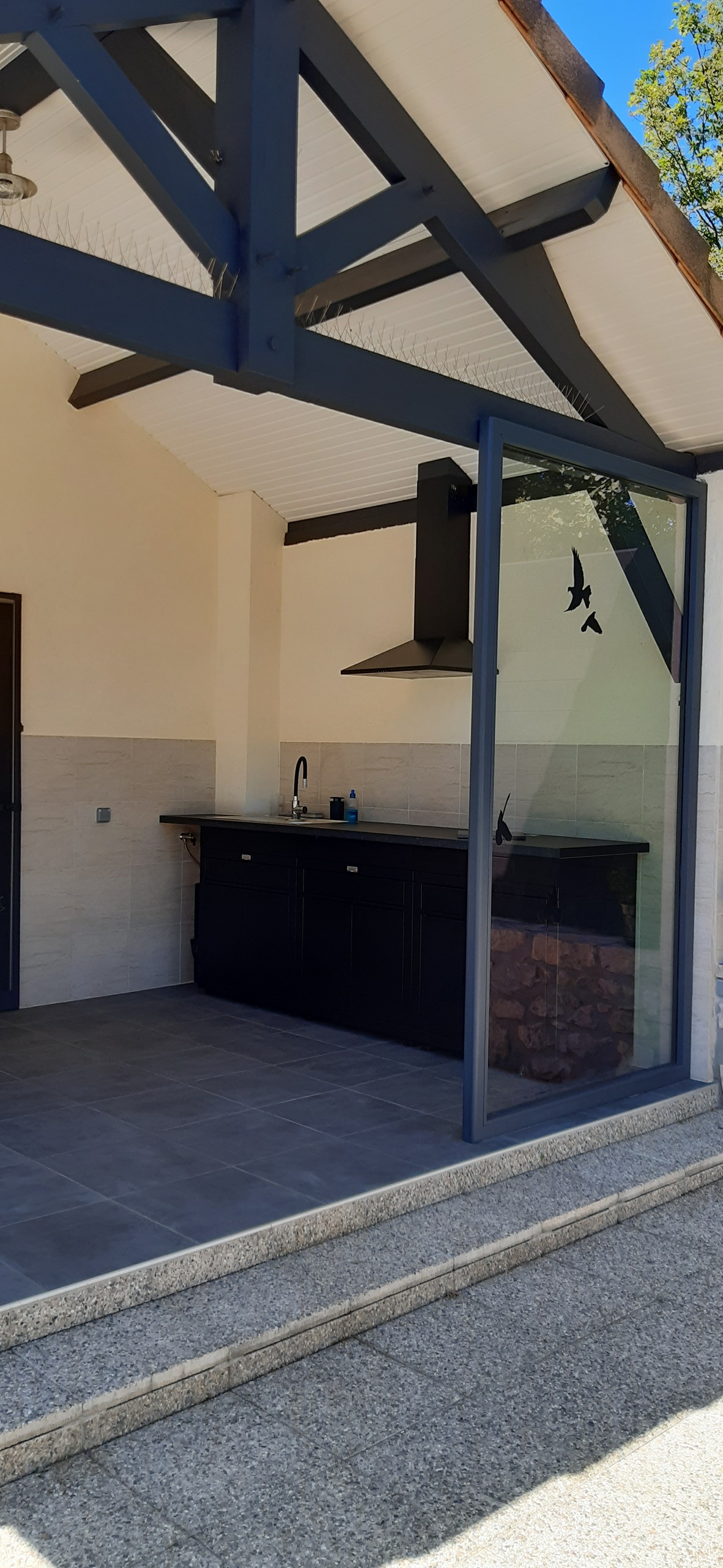 Terrasse couverte avec cuisine d’été équipée d’un barbecue électrique, d’une plancha électrique et d’un four – gîte naturiste DACANIRO