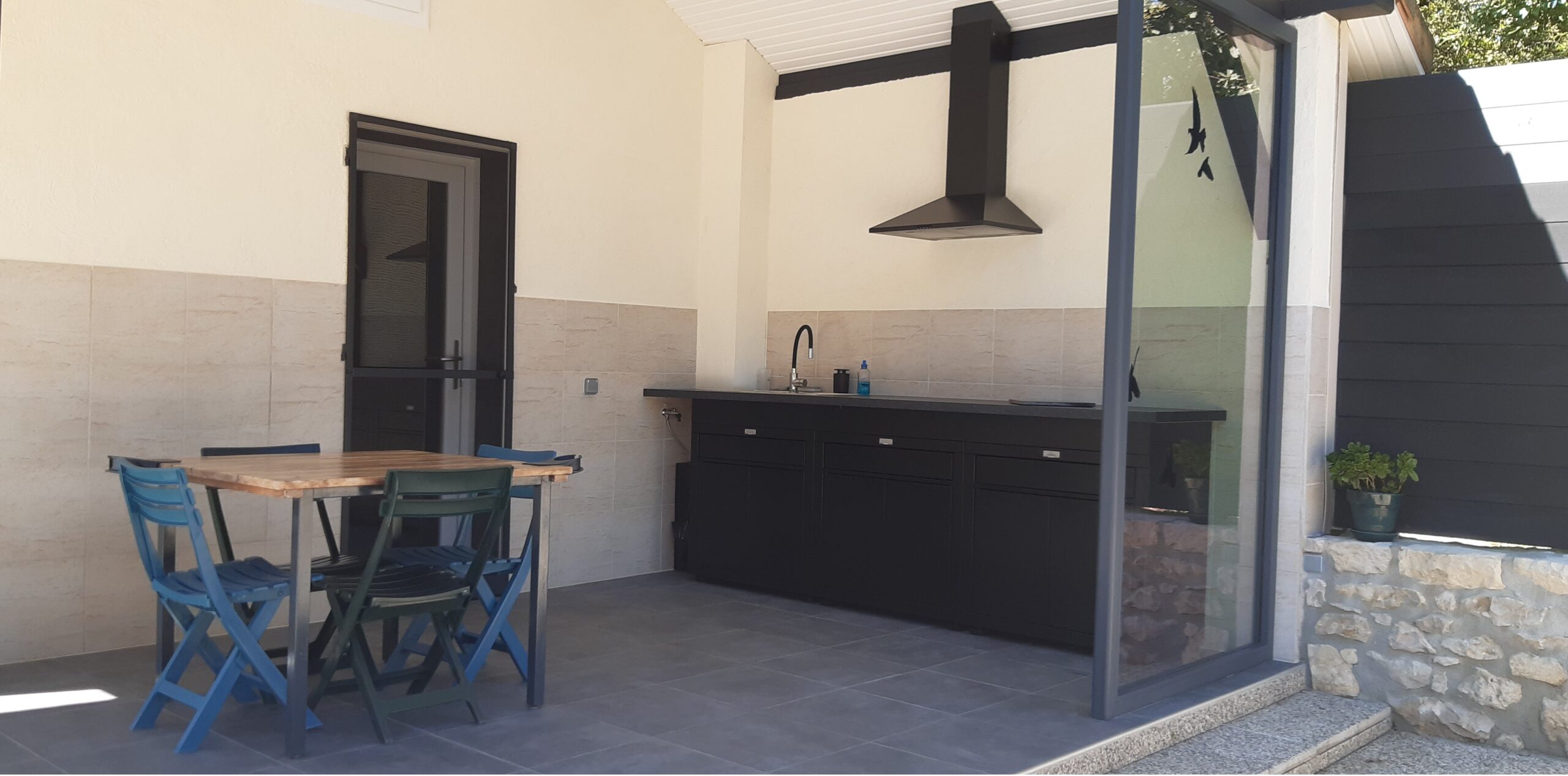Terrasse couverte avec cuisine d’été équipée d’un barbecue électrique, d’une plancha électrique et d’un four – gîte naturiste DACANIRO